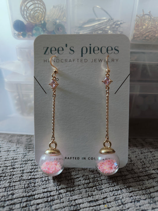 Long earrings, square pink gem, glass globe with pink star confetti, gold-plated stainless steel hooks, elegant and fun, playful sparkle, unique twist design, sophisticated and durable, chic accessory, special events, everyday outfit. - Premium Earrings from Zee's Pieces - Just $15! Gift ideas for women. 