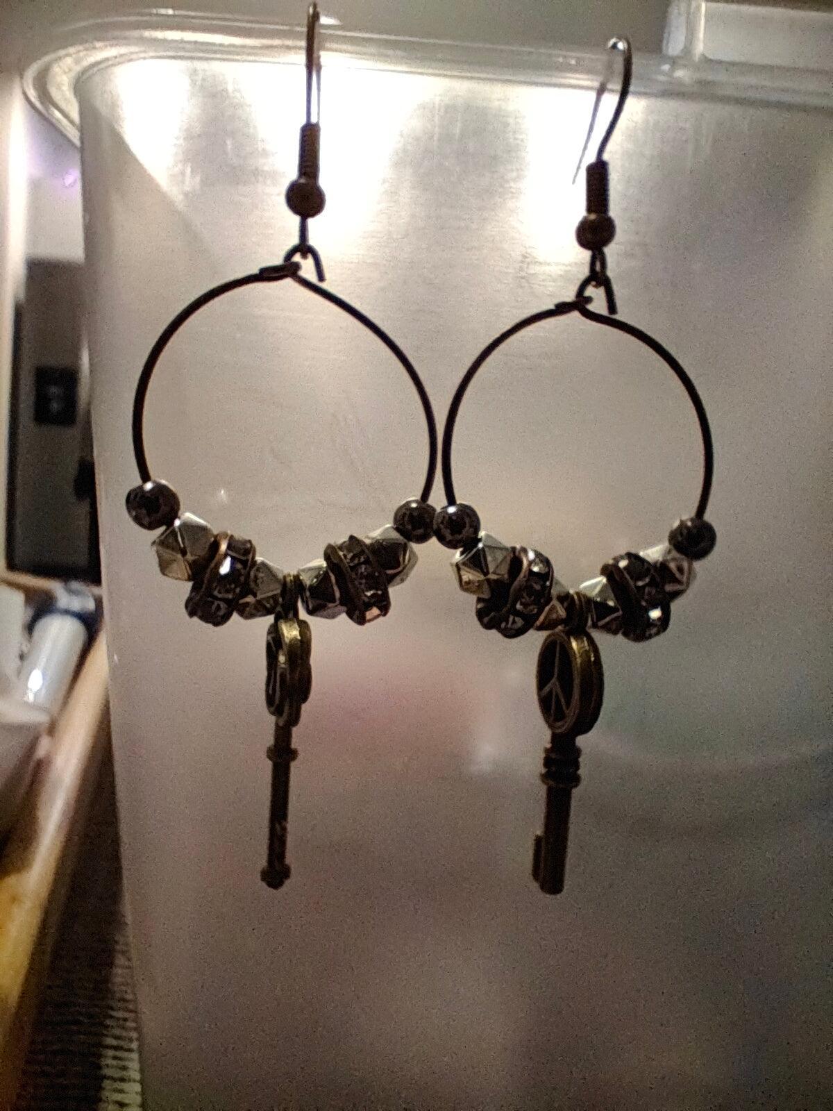 Unique earrings with bronze-colored hoops, round beads, rhinestone rounds, and key-shaped pendants from Zee’s Pieces, featuring distinct key designs, perfect for adding charm and individuality to any outfit, ideal for both casual and formal occasions. Only $15.00. 