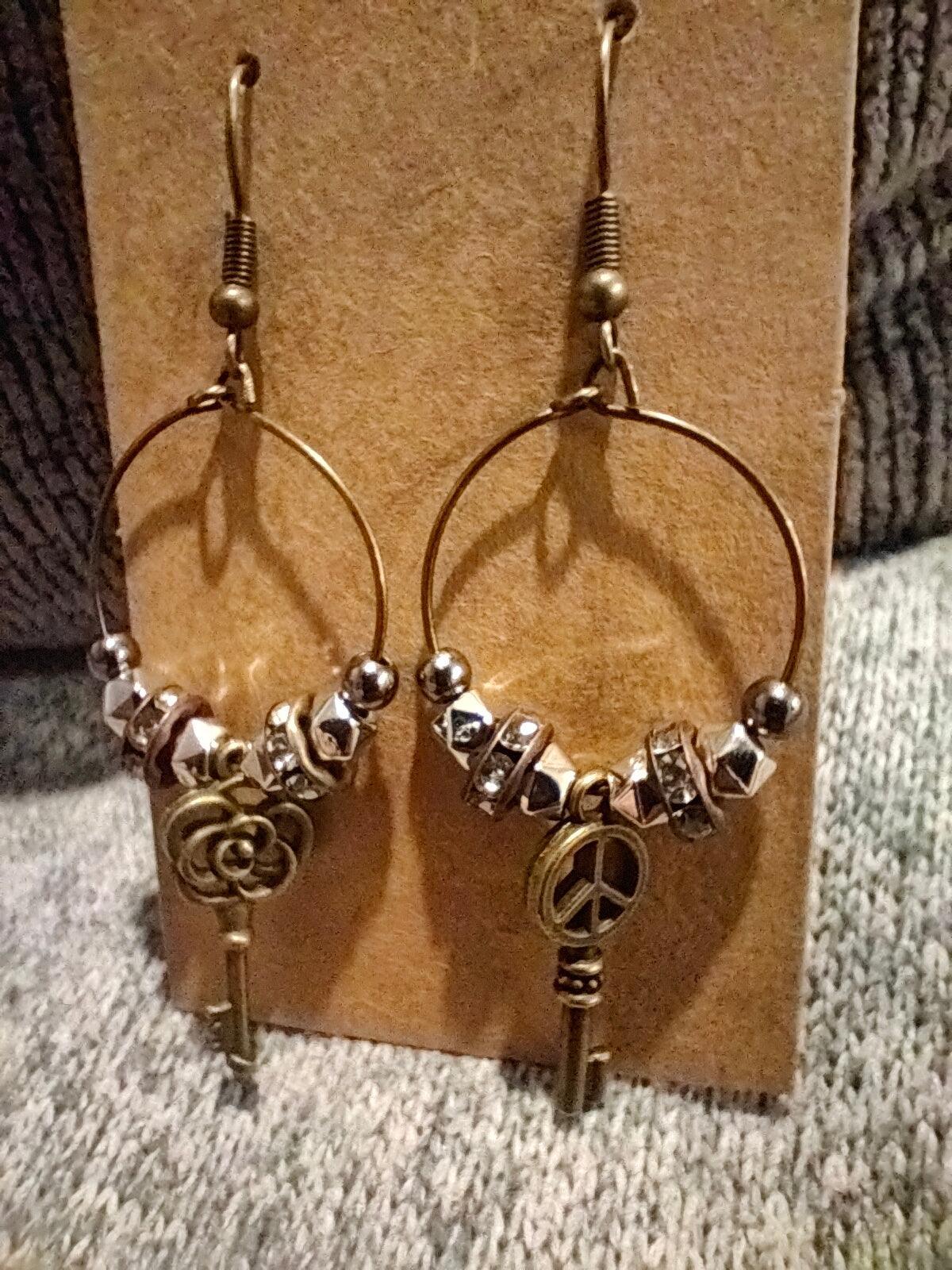 Unique earrings with bronze-colored hoops, round beads, rhinestone rounds, and key-shaped pendants from Zee’s Pieces, featuring distinct key designs, perfect for adding charm and individuality to any outfit, ideal for both casual and formal occasions. Only $15.00. 