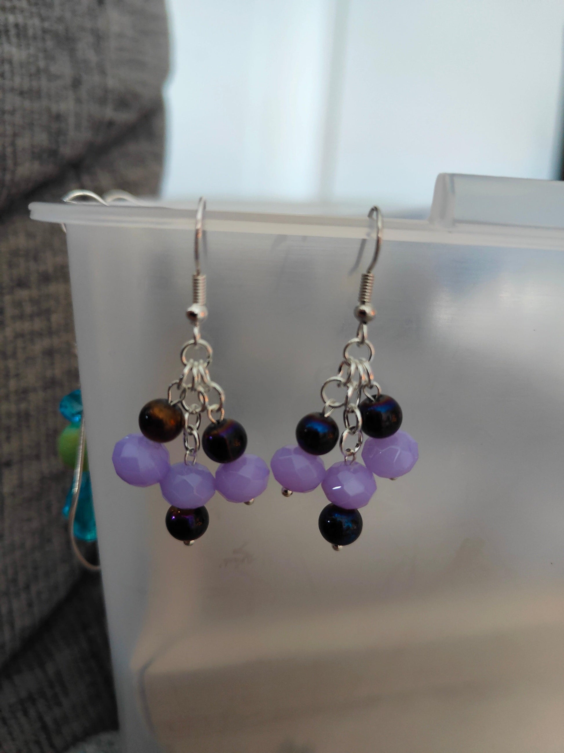 Gorgeous chandelier earrings with light lavender and dark purple glass beads from Zee’s Pieces, featuring faceted rondelle shapes and silver-toned metal components, perfect for adding elegance and sophistication to any outfit, ideal for both casual and formal occasions. Beaded earrings. Handcrafted jewelry. Gift ideas for women. Unique design.