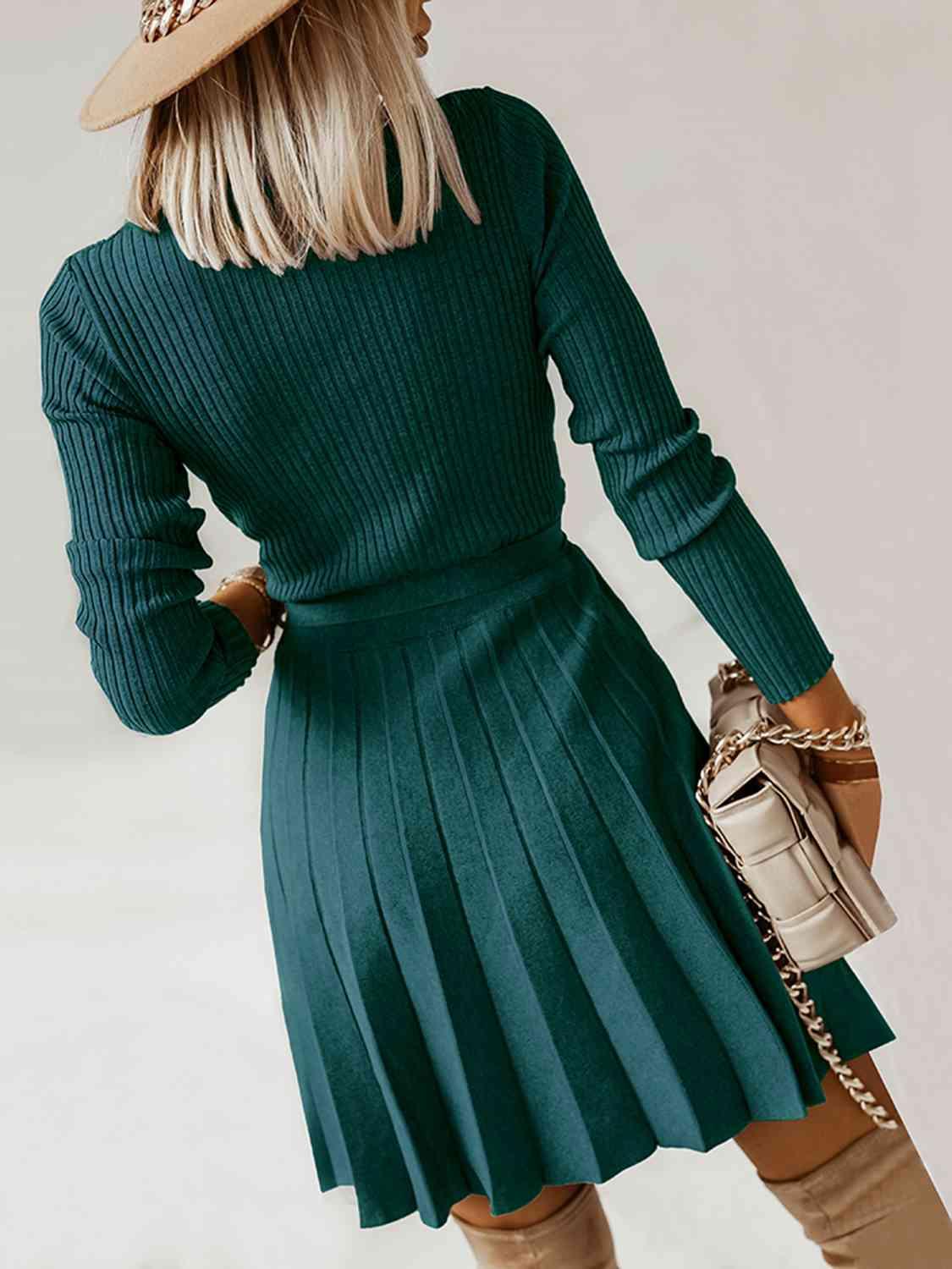 Surplice Neck Tie Front Pleated Sweater Dress - Zee's Pieces. Woman wearing Surplice Neck Tie Front Pleated Sweater Dress, fitted ribbed top, long sleeves, pleated skirt, stylish V-shaped neckline, cozy and chic fall and winter fashion. Army Green, Black, Charcoal Gray, and Khaki colors available. 